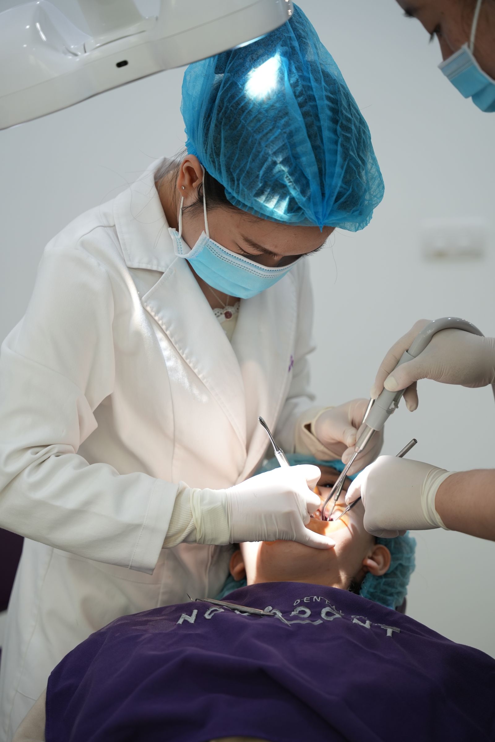 Dentista realizando um exame oral em uma clínica dental com instrumentos cirúrgicos.