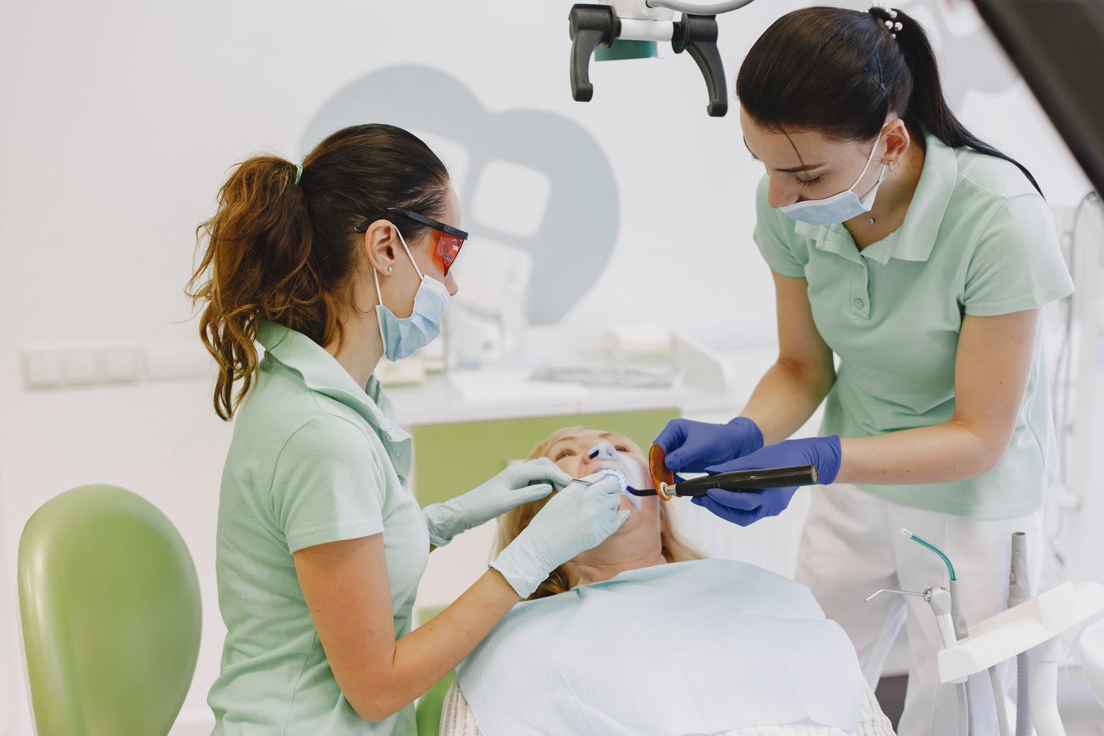 Dentistas realizando um procedimento dental em um paciente em uma clínica contemporânea.